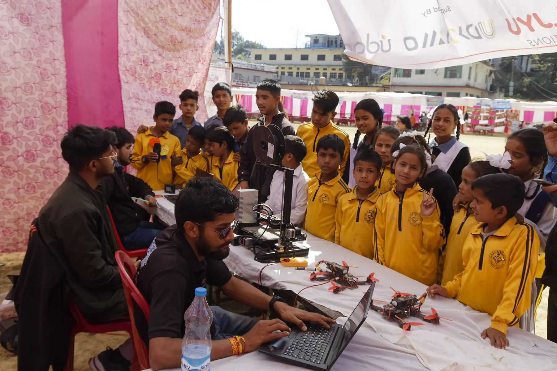 Students gathering around a practical technology demonstration